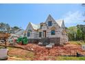 View of a new two-story home under construction, showcasing its exterior with wrappings and a brick base at 2328 Ballywater Lea Way, Wake Forest, NC 27587
