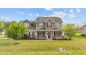 Charming two-story home features a covered front porch and well-manicured lawn, creating an inviting curb appeal at 24 Kaki Ct, Selma, NC 27576
