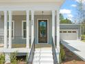 Inviting front door with sidelights and stairs leading to the covered porch, enhancing entry appeal at 250 Pilot Ridge Rd, Zebulon, NC 27597