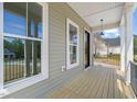 Cozy porch with wood flooring and large windows offers a peaceful outdoor space, enhancing the home's charm at 250 Pilot Ridge Rd, Zebulon, NC 27597