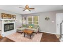 Inviting living room featuring hardwood floors, a fireplace, and a comfortable gray sofa at 2700 Ross Rd, Durham, NC 27703