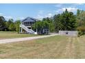 Exterior view of the two-story home with a screened-in porch, lawn, and gravel driveway at 283 Raynor Rd, Spring Lake, NC 28390
