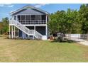 Two-story home with a screened-in porch, landscaped yard, and gravel driveway at 283 Raynor Rd, Spring Lake, NC 28390