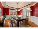 Formal dining room with hardwood floors, a chandelier, and large window for natural light at 3 Haycox Ct, Durham, NC 27713