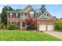 Charming two-story brick home with a well-manicured lawn, mature trees, and a two-car garage at 3 Haycox Ct, Durham, NC 27713