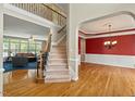 Bright foyer featuring hardwood floors, staircase, and a view into the living room and dining room at 3 Haycox Ct, Durham, NC 27713