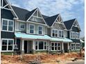 New two-story townhomes featuring gray siding, white trim, and black roofs, showcasing modern architectural design at 3020 White Rail Dr, Fuquay Varina, NC 27526