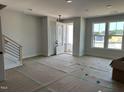 Spacious living room with large windows, modern railing staircase, and front door at 3020 White Rail Dr, Fuquay Varina, NC 27526
