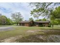 Brick home with a two car garage features a screened in porch and well-manicured lawn at 3121 Blue Hill Ln, Durham, NC 27703