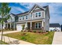 A beautiful, well-manicured lawn leads up to this craftsman style two story home with a two car garage at 353 Murray Grey Ln, Wake Forest, NC 27587