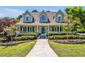 Charming home with a welcoming front porch, complemented by lush greenery and colorful flowerbeds at 40 Farrells Creek Rd, Apex, NC 27523