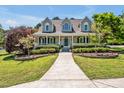 Inviting home with a cozy front porch, enhanced by beautiful landscaping and vibrant flower arrangements at 40 Farrells Creek Rd, Apex, NC 27523