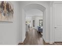 Elegant hallway with arched entryway, leading to an open floor plan with hardwood floors and neutral walls at 421 Raven Cliff St, Apex, NC 27523