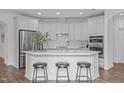 Bright kitchen with white cabinets, stainless steel appliances, a center island, and modern stools at 421 Raven Cliff St, Apex, NC 27523