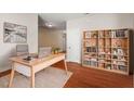 Well-lit home office with a modern desk, stylish bookcase, and hardwood floors for a productive workspace at 5417 Razan St, Raleigh, NC 27616