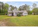 Spacious front yard with a single-story home, lovely landscaping and mature trees at 545 Irvan St, Clayton, NC 27520