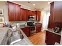 Well-equipped kitchen featuring stainless steel appliances, granite countertops, and hardwood floors at 5515 S Roxboro St # 16, Durham, NC 27713