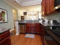 Open kitchen with stainless steel dishwasher, granite countertop, and hardwood floors at 5515 S Roxboro St # 16, Durham, NC 27713