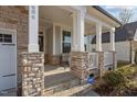 Inviting front porch featuring stone support columns, rocking chair, and well-maintained landscaping at 604 Craftsman Ridge Trail, Knightdale, NC 27545