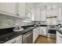 Updated kitchen featuring granite counters, white cabinets, subway tile backsplash, and stainless steel appliances at 604 Mills St, Raleigh, NC 27608