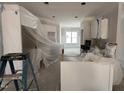 Bright, unfinished kitchen with white cabinets, ample counter space, and natural light from a large window at 69 Tee Dr, Selma, NC 27576