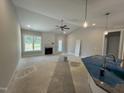 Bright living room featuring a fireplace, ceiling fan and large windows providing natural light at 69 Tee Dr, Selma, NC 27576