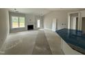 Unfinished living room area featuring a fireplace, large window and access to the home's exterior at 69 Tee Dr, Selma, NC 27576