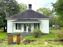 Inviting single-story home with a covered porch, small garden, and a well-maintained yard at 702 Mill St, Wake Forest, NC 27587