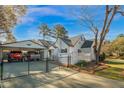 Rear exterior view featuring a covered carport, fenced yard, and well-maintained property at 708 W Pope St, Dunn, NC 28334