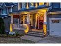 A cozy front porch features brick accents, a red front door, and a welcoming atmosphere at 725 Ancient Oaks Dr, Holly Springs, NC 27540