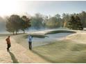 Picturesque golf course view with golfers and morning mist at 725 Ancient Oaks Dr, Holly Springs, NC 27540