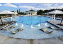 Resort-style pool area with in-water loungers, sun umbrellas, and clubhouse at 725 Ancient Oaks Dr, Holly Springs, NC 27540