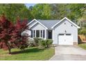 Charming home with a well-manicured lawn, mature trees, and attached one car garage at 901 Clifford Dr, Durham, NC 27704