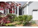 Close up of home's front door, surrounded by greenery, with black shutters at 901 Clifford Dr, Durham, NC 27704