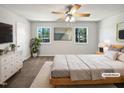 Bright bedroom featuring a ceiling fan, two windows, carpeted floors, and a double bed at 901 Forge Rd, Durham, NC 27713