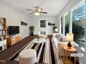 Bright living room with large windows, modern furniture and a ceiling fan at 901 Forge Rd, Durham, NC 27713