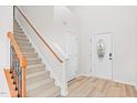Bright entryway featuring wood-look flooring, a staircase, and a decorative front door at 104 Rosebud Ln, Durham, NC 27704