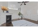 Open living room featuring a fireplace, staircase, wainscoting, and plenty of natural light at 10410 Sablewood Dr # 111, Raleigh, NC 27617
