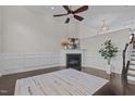 Inviting living room with cozy fireplace, wainscoting, ceiling fan, and staircase leading to the upper level at 10410 Sablewood Dr # 111, Raleigh, NC 27617