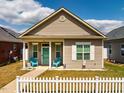 Inviting single-story home with a quaint front porch and a cheerful blue door framed by neat landscaping at 110 Plott Hound Dr, Clayton, NC 27520