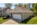 Angle view of a single-story home with a two-car garage and well-maintained lawn at 112 Pink Dogwood Ln, Mebane, NC 27302