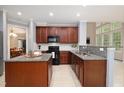 Well-equipped kitchen featuring granite countertops, cherry wood cabinets, and modern appliances at 1120 Scholastic Cir, Durham, NC 27713