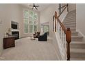 Spacious living room with soaring ceilings, large windows, a fireplace, and staircase at 1120 Scholastic Cir, Durham, NC 27713