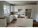 Bright kitchen with white cabinetry, a large window, and an open layout ready for appliances at 12 Gates St, Roxboro, NC 27573