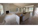 Open kitchen featuring an island with a sink and white cabinets, next to a living room with a fireplace at 125 Tee Dr, Selma, NC 27576