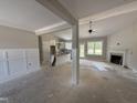 Open-concept living room with fireplace, ceiling fan, and views into kitchen with island at 125 Tee Dr, Selma, NC 27576