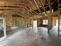 Open-concept space under construction with exposed beams, large windows and a bright, airy feel at 125 Tee Dr, Selma, NC 27576