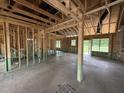 Spacious living room under construction, with exposed wooden beams and multiple window openings at 125 Tee Dr, Selma, NC 27576