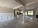 Spacious living room open to the kitchen featuring white wainscotting and lots of natural light at 125 Tee Dr, Selma, NC 27576