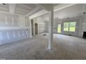 Unfinished living room with natural light and visible framing, offering a spacious open-concept design at 125 Tee Dr, Selma, NC 27576